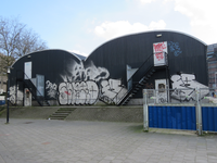 829343 Gezicht op de achterkant van de loods van de fietsenstalling op het Smakkelaarsveld te Utrecht, met veel graffiti.